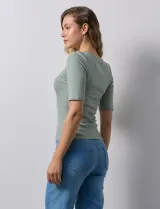Remera rosa de tejido rib, con cuello redondo y manga corta.