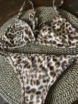 Conjunto de bikini con estampado de leopardo. El corpiño es de triángulos movibles con breteles regulables y espalda para atar. La bombacha es regulable a los costados.