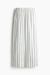 Pantalón capri de corte amplio con cintura elástica y estampado a rayas verticales azules sobre fondo blanco.