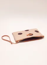 Sobre de algodón a rayas verticales de colores naranja, rosa, marrón, rojo y blanco. Tiene cierre superior con cremallera y tira de cuero marrón para la muñeca.