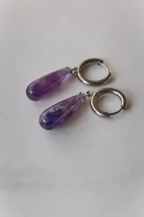 Aros colgantes de acero quirúrgico hipoalergénico con dije de piedra natural en forma de gota color azul oscuro.