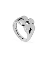 Anillo plateado de metal con forma de flor calada.