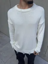 Sweater de hilo blanco roto, de corte holgado, con cuello redondo y mangas largas. Presenta detalles rotos en cuello, puños y ruedo.