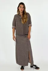 Pollera larga de tiro alto color marrón con estampado abstracto y abertura lateral.