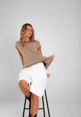 Blusa de hilo tejido a rayas horizontales en tonos gris y negro, de corte suelto y oversize, con cuello redondo y mangas cortas.