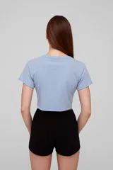 Remera cropped color rosa con estampado de conchas marinas en color rojo, corte holgado y cuello redondo.