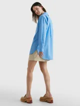 Camisa celeste de popelín de algodón orgánico, corte oversize con hombros caídos, cuello inglés, bolsillo de parche en el pecho y logo bordado en la manga.