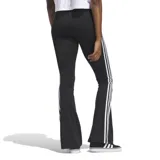 Calza Adidas negra con corte ajustado, cintura elástica, perneras acampanadas y tres rayas blancas en los laterales.