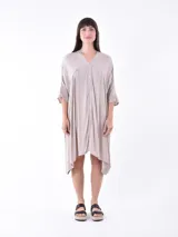 Vestido color beige con corte irregular, mangas cortas y botones frontales.