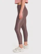 Calza deportiva negra con tela brillante, tiro alto y cintura en forma de "V" con silicona interior.
