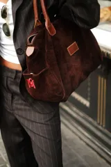 Bolso de viaje color verde oliva con detalles en cuero marrón.