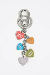Llavero de metal plateado con mosquetón y argolla. Incluye cinco dijes colgantes en forma de corazón esmaltados en colores: rojo, naranja, azul, verde oliva y lila, cada uno con el logo "BIMBA Y LOLA" grabado.