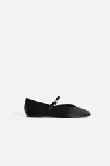 Zapato tipo bailarina color negro con efecto satinado, punta redonda y tira con hebilla ajustable.