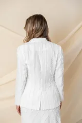 Blazer blanco de crepé satén con flecos de seda, bolsillos ojal y botón de nácar. Ideal para cóctel o civil.