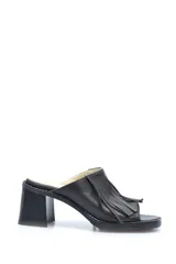 Zueco de cuero negro con detalles de flecos y tacón medio.
