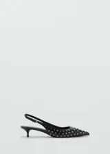 Zapato de tacón kitten color negro, con punta fina, diseño destalonado y tachuelas decorativas.