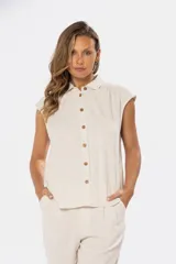 Camisa color beige de lino con botones de madera, cuello clásico y mangas cortas.