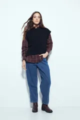 Chaleco tejido sin mangas de color negro, con cuello redondo y diseño de textura sutil. Presenta un corte recto con terminaciones acanaladas en el ruedo y hombros levemente estructurados.