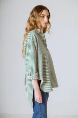 Camisa holgada de manga larga con rayas verticales verdes y blancas. El ruedo es más largo en la parte trasera.