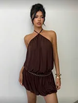 Vestido corto marrón con cuello halter, cintura elastizada con detalle de tachas y falda con volado.