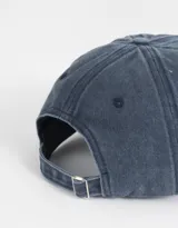 Gorra de béisbol azul denim con efecto lavado y bordado frontal con la palabra "Tokyo" en blanco. Ajuste trasero con hebilla metálica.