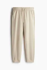 Pantalón de jogging color beige, de corte recto, con cintura elástica ajustable con cordón y puños acanalados.