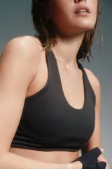 Top deportivo negro con breteles cruzados en la espalda y espalda descubierta.