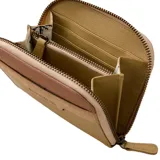 Billetera pequeña de cuero sintético color beige con detalles en marrón. Tiene cierre de cremallera y el logo de Rip Curl grabado en el frente.