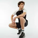 Camiseta deportiva negra con mangas cortas raglán en color blanco y logo pequeño en el pecho.