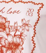 Remera de algodón color rosa con cuello redondo y mangas cortas. Estampa frontal con moldura, flores y texto "With love from Barcelona".