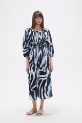 Vestido midi holgado con estampado abstracto en tonos azul marino, azul claro y blanco. Presenta cuello mao, botones frontales y cordón ajustable en la cintura.
