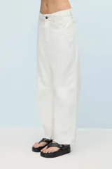 Jean blanco de denim 100% algodón, de calce relajado y pierna semi bombe. Cuenta con recortes en la entrepierna y pinzas que generan un efecto curvo. Con ruedo al corte y desflecado, doble bolsillo trasero del lado derecho, badana y avíos marcarios personalizados.