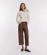 Blusa de punto color crema, con cuello alto y mangas largas.
