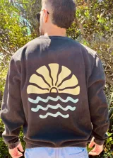 Buzo negro con estampa de sol naciente y olas en la espalda.
