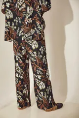 Pantalón palazzo de tela gamuzada con estampado floral exclusivo, detalles metálicos y tajos en el ruedo.