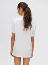 Remera blanca de corte cuadrado y holgado, con estampado pequeño de un velero en el pecho.