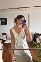 Vestido corto plateado con escote en V, sin mangas y bordado en el frente.