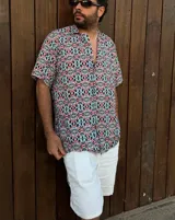 Camisa de manga corta con cuello clásico y estampado geométrico multicolor.