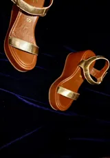Sandalias de cuero color marrón con plataforma de madera y tira ancha sobre los dedos.
