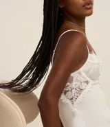 Camisón corto blanco de microfibra con breteles finos regulables y detalle de encaje floral en el busto.