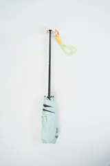 Paraguas plegable de color beige claro con la palabra "hello." estampada en azul. Incluye un asa de mano tipo correa en tonos amarillo y rosado.