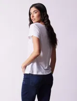 Remera blanca de lino, marca Zac & Rachel, con escote en V, abertura con botones y frunce en la parte delantera.
