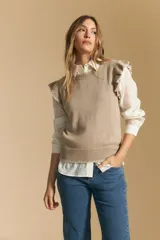 Chaleco de tejido de punto color beige, con cuello redondo y volados en las sisas con terminación en contraste.