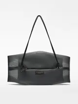 Bolso negro de malla con bolsa interior de piel y forro de algodón orgánico. Tiene cierre de cremallera lateral, asa corta fija y etiqueta exterior con logo.