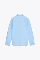 Camisa blanca de algodón con cuello con volantes y mangas largas con puños fruncidos.