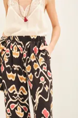 Pantalón de seda con viscosa, estampado con motivos geométricos en tonos marrones, beige y rojo. De calce recto y fluido, con cintura elastizada.
