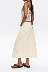 Falda midi color crudo con bordados florales y corte evasé.