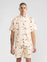 Camisa manga corta con cuello camisero, de corte recto y estampado de sirenas en tonos naranja y amarillo.