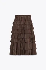 Falda midi color verde oliva confeccionada en tejido con viscosa. Presenta cintura elástica y detalle de volantes en el mismo tejido.