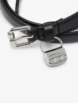 Cinturón delgado de cuero negro con hebilla rectangular plateada y un dije colgante metálico con el logo de la marca grabado.